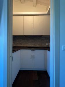 una cocina vacía con armarios blancos y una puerta azul en Villa Tilly, en Trarivi
