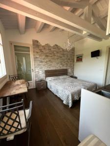 a bedroom with a bed and a brick wall at Villa Tilly in Trarivi
