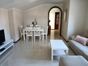 ein Wohnzimmer mit einem weißen Tisch und einem Sofa in der Unterkunft Rodeira in Cangas