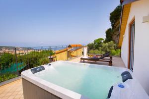 bañera de hidromasaje en el balcón de una casa en Eterea Charming Suites, en Sorrento