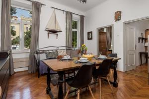Il comprend une cuisine et une salle à manger avec une table et des chaises en bois. dans l'établissement 4 Bedroom Apartment, à Rijeka