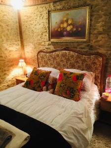 Maison Blanche De Hudson في Cussac: وجود دبدوب يجلس على سرير مع وسادتين