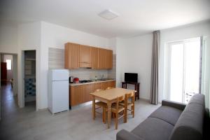 a kitchen with a couch and a table in a room at Appartamenti Luce Vieste in Vieste