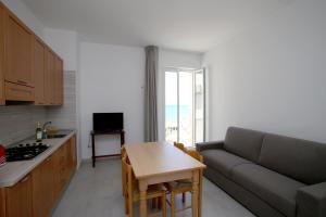 a kitchen and living room with a couch and a table at Appartamenti Luce Vieste in Vieste +37 photos