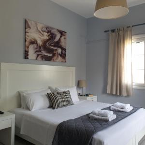 a bedroom with a large white bed with towels on it at Sivotahomes-blu in Sivota