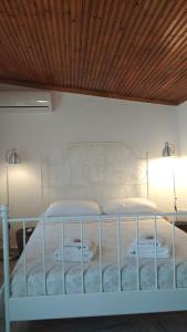 a bed in a bedroom with a wooden ceiling at Dino's Cottage in Sarti