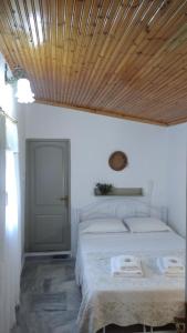 a bedroom with a bed with a wooden ceiling at Dino's Cottage in Sarti