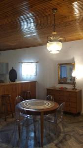 une salle à manger avec une table et des chaises et un plafond dans l'établissement Dino's Cottage, à Sarti