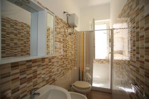 a bathroom with a toilet and a sink and a shower at Appartamenti Luce Vieste in Vieste