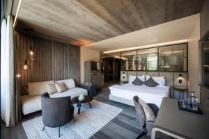 een hotelkamer met een bed en een bank bij Alpine Spa Resort Viktoria in Avelengo