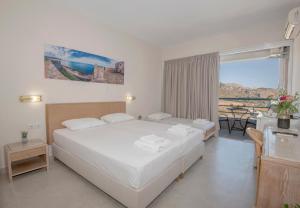 a bedroom with a large white bed and a balcony at Sokol Resort in Damnoni