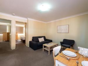 a living room filled with furniture and a table at Villa Nova Motel in Toowoomba