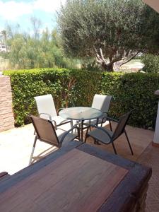 a table and four chairs and a table and a tree at La Torre Golf Resort, Mero, Torre-Pacheco, Murcia in Murcia