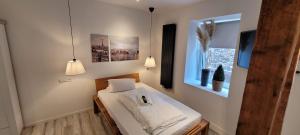 Hotel Hoppe في فيتن: غرفة نوم بسرير وملاءات بيضاء ونافذة