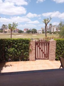 a wooden gate on a patio with a golf course at La Torre Golf Resort, Mero, Torre-Pacheco, Murcia in Murcia