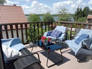 a patio with two chairs and a table on a balcony at Owocowe Wakacje - Apartament nad jeziorem in Mikołajki