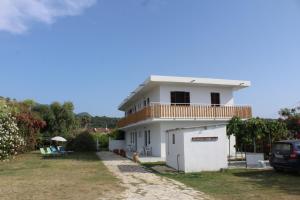 a white house with a balcony and a yard at Anastazia's Seaside Apartments in Roda