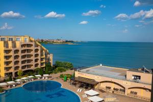 a view of a resort with a swimming pool and the ocean at Apartament Midia in Aheloy