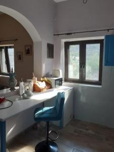 a kitchen with a table and a blue chair at Secret Sea Hideaway. in Areopolis