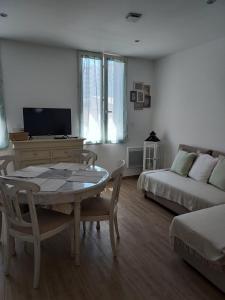a living room with a table and a couch at Toulon, soleil et douceur I in Toulon