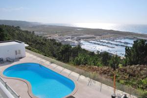 a swimming pool with a view of the ocean at Apartamentos 7 saias in Nazaré
