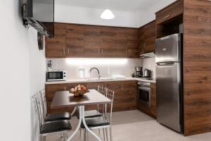 a kitchen with wooden cabinets and a table with chairs at Dinos Apartments in Vasiliki +22 photos