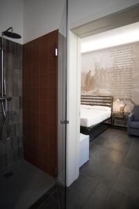 uma casa de banho com um chuveiro e um quarto com uma cama em BB LETTERARIO em Ravenna