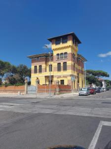 un bâtiment jaune sur le côté d'une rue dans l'établissement La casa di Francesco, à Marina di Pisa