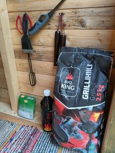 a bag hanging on a wooden wall with a knife at Venejoen Piilo - Loimu in Kontiolahti