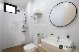 a white bathroom with a sink and a mirror at The Quartz Melaka By I Housing in Melaka