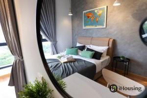 a bedroom with a bed with green pillows at The Quartz Melaka By I Housing in Melaka