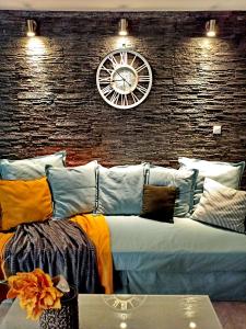 a large couch with a clock on a brick wall at Hapilis in Alexandroupoli