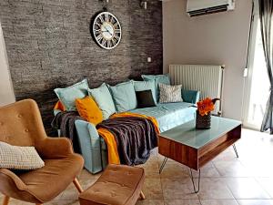 a living room with a couch and a clock on the wall at Hapilis in Alexandroupoli