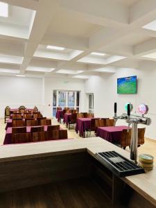 una sala de conferencias con mesas y sillas púrpuras en Hostel Bistrița en Eforie Sud