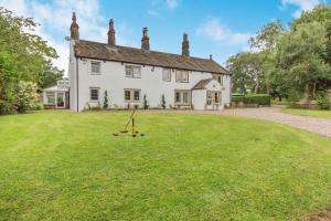 a large white house with a yard with a playground at Fence House in Burnley