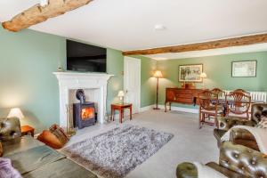 a living room with a fireplace and a piano at Fence House in Burnley