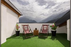 a balcony with two chairs and a view of mountains at Apart AUSTRIA in Finkenberg