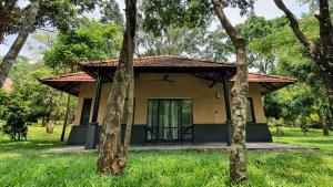 a small house in the middle of a field at Klov Resort & Spa in Wayanad