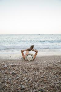 a woman laying on the beach with her head in the sand at Tree Houses Hotel in Fethiye
