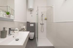 a white bathroom with a shower and a sink at Lux Apartments in Rijeka +26 photos