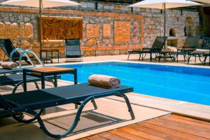 a pool with tables and chairs next to a pool at Tree Houses Hotel in Fethiye