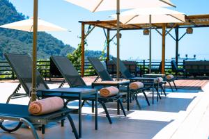 a row of chairs and umbrellas on a patio at Tree Houses Hotel in Fethiye