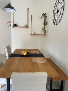 a wooden table in a kitchen with a clock on the wall at Incantevole Appartamento - Sentiero al Mare in San Benedetto del Tronto