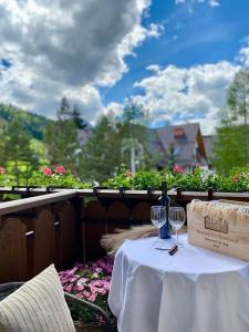 a table with a bottle of wine and two glasses at Hotel Nosal Ski & Wine in Zakopane