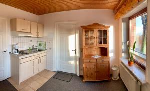 a kitchen with white cabinets and a sink and a window at "Ferienhof Alte Mühle" W 2 in Bannesdorf