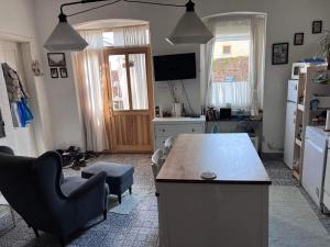 a living room with a kitchen with a table and chairs at Kemencésház Apartman in Kővágóörs +11 photos