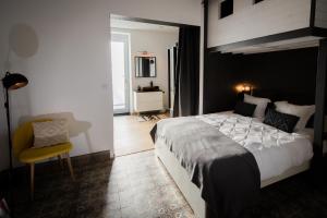 Braives的住宿－Au Calme de Hosdent，一间卧室配有一张大床和一张黄色椅子