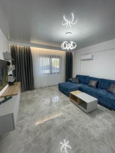 a living room with a blue couch and a table at Near Sea Apart Mamaia Nord in Mamaia Nord