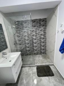 a bathroom with a shower and a sink and a mirror at Near Sea Apart Mamaia Nord in Mamaia Nord