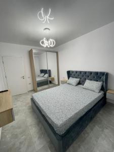 a bedroom with a large bed and a mirror at Near Sea Apart Mamaia Nord in Mamaia Nord